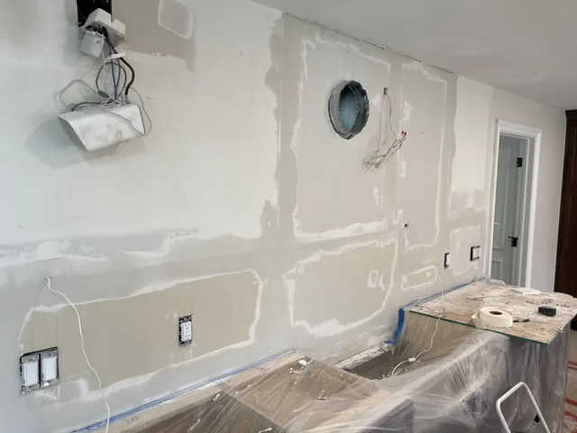 Joint compound on drywall seams and patches above cabinets covered with plastic