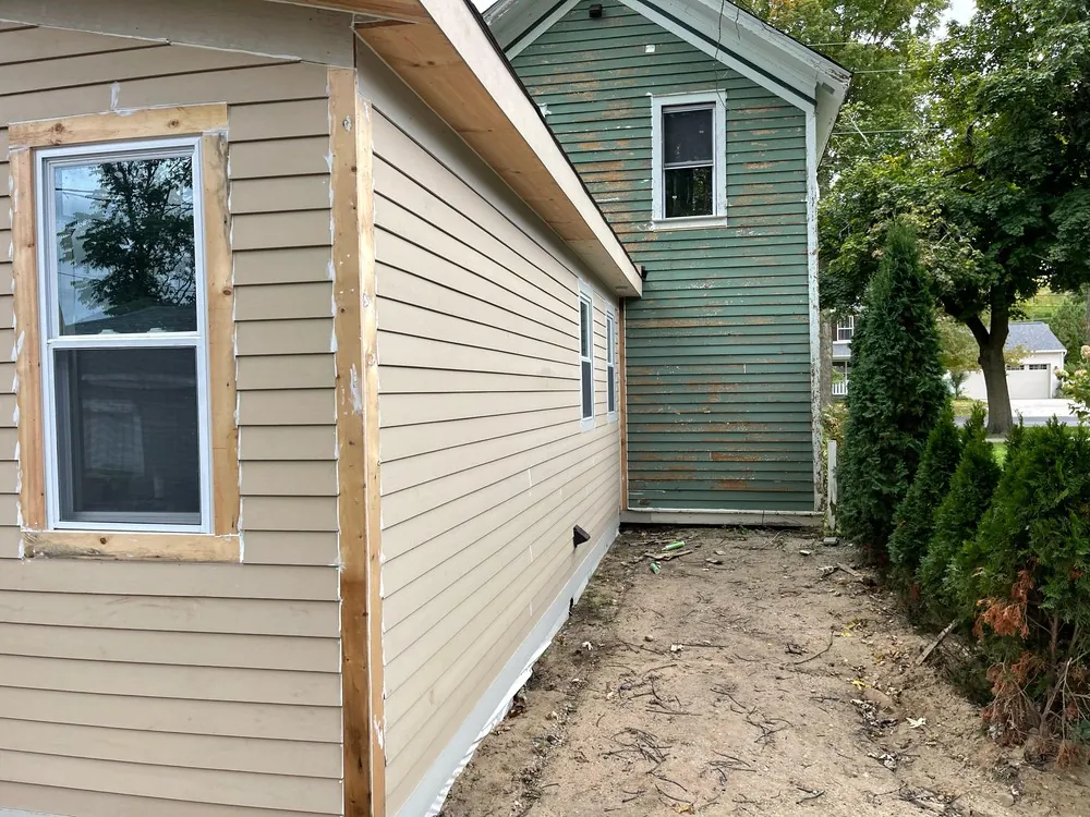 Bare wood window casing and a corner board beside horizontal house siding