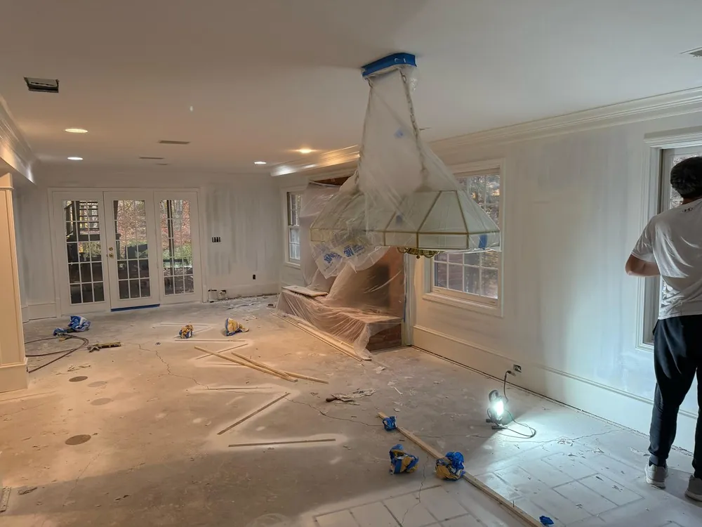 Living room during preparation with a covered light fixture and fireplace