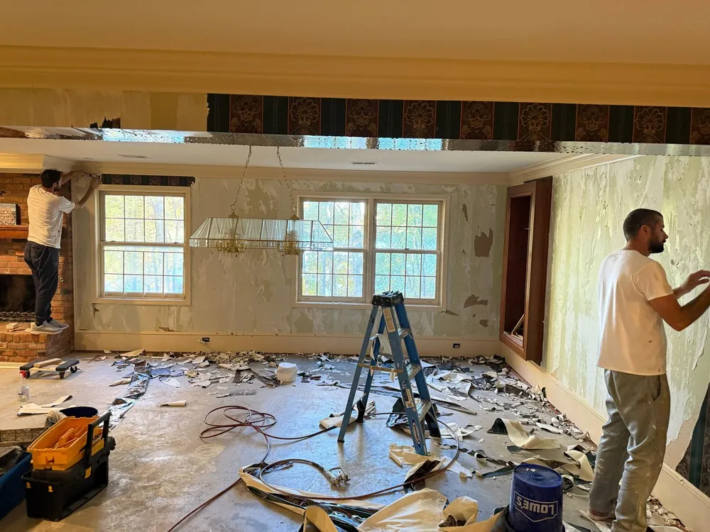 Old wallpaper being stripped from a living room wall