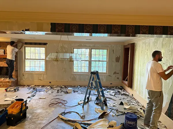 Wallpaper being stripped from an interior wall.