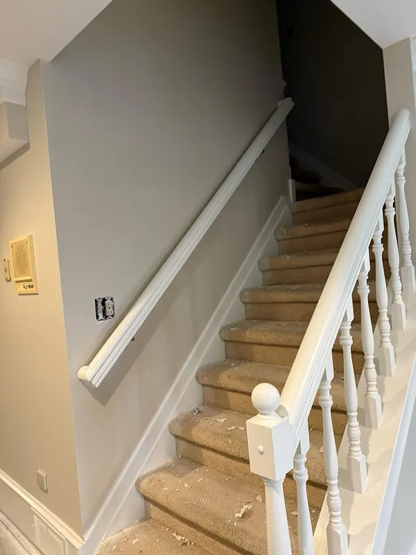 Painted stairwell walls beside a white rail.