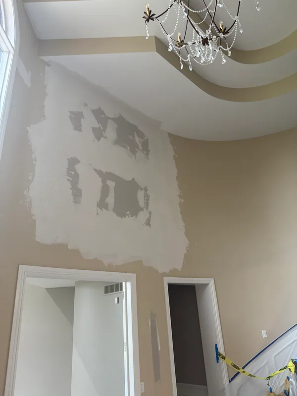 Tall interior wall with broad patching areas above two doorways.