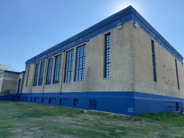 Beige brick building with blue window frames, cornice and lower walls.